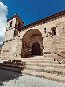 Fachada principal de la Iglesia de San Pedro Advincula, en Pedro Bernardo. La fotografía está tomada desde una perspectiva algo contrapicada. Unas escaleras de piedra llevan a la entrada principal del templo, que tiene una única torre en la parte izquierda
