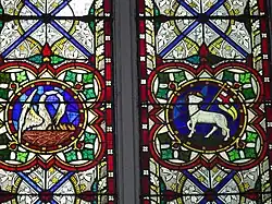 Pelícano vulnerado y Cordero de Dios con bandera con cruz triunfal, ambos símbolos de la Resurrección (vidriera, Irlanda, siglo XIX)