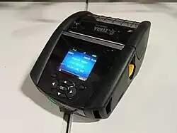 Una impresora térmica portátil de etiquetas sobre una mesa.