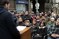 Orador ante público sentado, en la esquina de 18 y J G Araújo