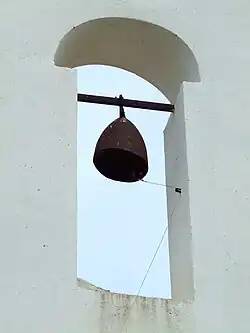 El obús en la espadaña, haciendo de campana.