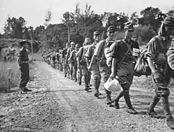 Tropas japonesas desarmadas marchando hacia un complejo de prisioneros de guerra en Api después de rendirse a los australianos el 8 de octubre de 1945.