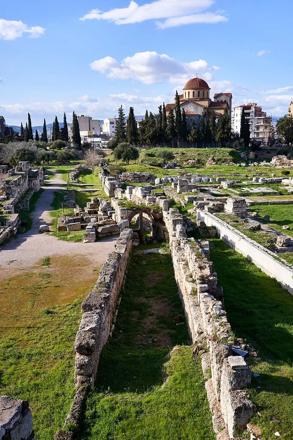Via Sagrada Eleusina (a la izquierda) vista desde dentro de la muralla en su inicio en la Puerta Sagrada junto al Eridanos (derecha) en el cementerio.