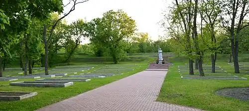 Un monumento a las víctimas del nazismo en uno de los bastiones, a los lados hay fosas comunes que son trincheras cerradas con cuerpos