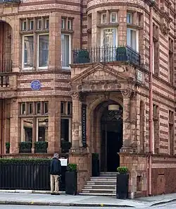 exterior de la casa de ladrillo rojo, con la placa azul en la fachada