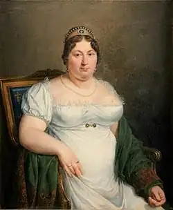 Retrato de mujer sentada, pelo recogido y diadema. Lleva un vestido blanco y un mantón verde.