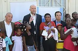 Personeros de gobierno junto a inmigrantes haitianos, en 2015.