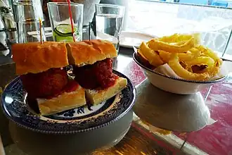 Un sándwich de albóndigas con aros de cebolla en un restaurante de Londres
