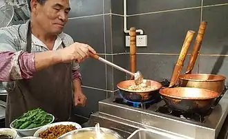 Fideos de arroz mi xian (米线) cocinados en ollas de cobre (铜锅), China.