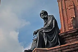 Fray Juan Pérez Marchena con una carta geográfica y un compás calculando la distancia a las Indias.