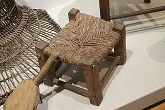 Escabel o taburete antiguo fabricado con madera y enea