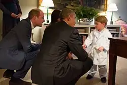 George is wearing a white bathrobe as he shakes hands with the then American president