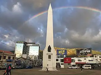 Foto del obelisco del centro de Ibarra con un arcoíris en el fondo.