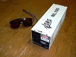 Imagen de una caja metálica blanca, versión comercial del laser de N2 con la inscripción SRS.