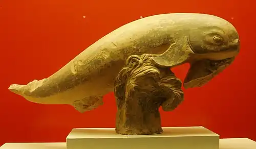 Fragmento de terracota con forma de delfín saltando sobre las olas. Probablemente acrótera de un tesoro. 400 a. C.