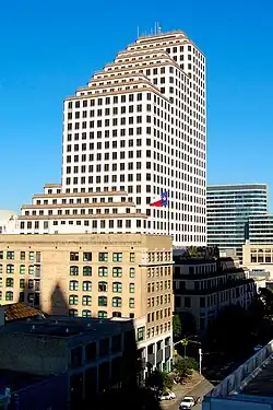 View from perhaps another building of One American Center. The building is white with red lining, and staircases at the top.