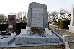Tombe avec en tête grande stèle portant plaque sur laquelle est gravé : « Gloire à nos élus héros et martyrs de la Résistance assassinés par les nazis ». Au-dessous, 11 noms, dont celui de Corentin Cariou. En bas : « Ils sont morts pour que vive la France !