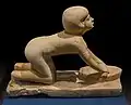 Figurilla del Imperio Antiguo de Egipto que representa a una mujer moliendo arrodillada.