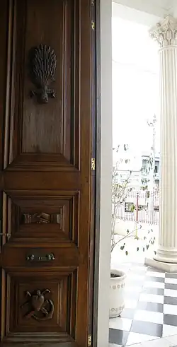 Detalles tallados en la puerta de entrada al Museo Solari de Fray Bentos, con elementos simbólicos de la Sociedad Cosmopolita de Socorros Mutuos