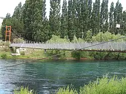Puente peatonal cruzando el río en Villa Llanquín.