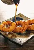 Picarones peruanos siendo bañados con miel de chancaca