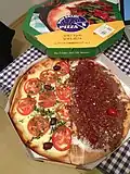 Las pizzas brasileñas pueden tener casi cualquier sabor. En la foto, una pizza mitad mozzarella, tomate, aceitunas y especias (salada) y mitad chocolate, coco y cerezas (dulce).
