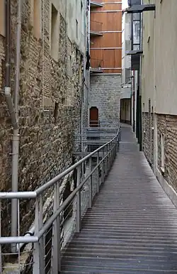 El nivel inferior queda interrumpido por la torre de Joan Caritat