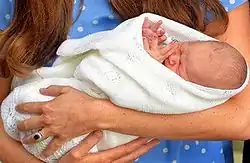 A newborn Prince George wrapped in white cloth
