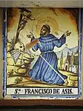 Retablo cerámico de San Francisco de Asís en calle Calvario