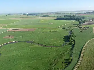Vista del río Milanillos a su paso por la localidad desde globo aerostático. A la derecha el histórico Puente del Tesoro