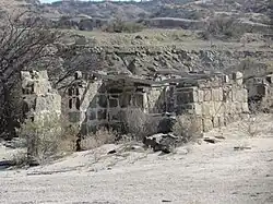 Breve Descripción: El Parque Provincial Ischigualasto es mundialmente famoso por su riqueza paleontológica. Sus sedimentos guardan las evidencias de todo el proceso evolutivo del triásico (Era Mezozóica). Además destacan una gran variedad de registros arqueológicos que hacen mención a la actividad humana que se desarrolló en tiempos remotos. En Ischigualasto, entre 1920 y 1954 se explotaron 3 minas de carbón. El carbón extraído era llevado a lomo de mula a las fraguas y los hornos de Huaco y Jáchal, a unos 70 km. Económicamente estas explotaciones eran muy pobres, por tratarse de mineral carbonoso de escasa pureza, razón por la cual fueron abandonadas. Los mineros que trabajaron estas minas, realizaron algunos conjuntos habitacionales muy rústicos utilizando material de la zona. Entre estas se encuentra la vivienda mostrada la cual fue construida con piedra, barro y ramas. Estas construcciones son de escasa altura y se ubican en una terraza reparada de los vientos entre el cauce de un río y cerros altos.