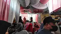 Una ceremonia de boda típica en Indonesia, completa con una orquesta en un escenario. El público puede solicitar una canción para que la orquesta la cante, o pueden subir al escenario y cantar la canción que deseen.