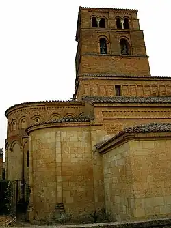 Torre-campanario y ábsides, de estilo románico.