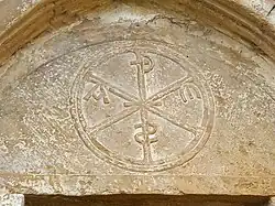 Crismón trinitario en el témpano de la portada