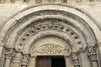 Tímpano en el portal oeste de la iglesia de Santa María (Santa Cruz de la Serós), mostrando chrismón y leones