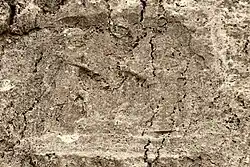 Sar-e Pol-e Zahab, relieve III. Guerrero sin barba pisoteando a un enemigo, frente a una diosa.[1]​