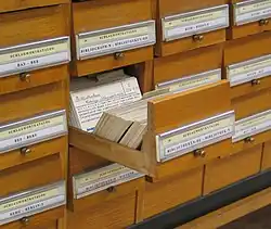 un cajón abierto de una biblioteca con tarjetas pequeñas adentro escritas a mano