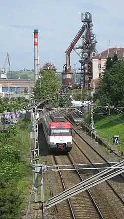Trazado del ferrocarril en el que se ve que el tren está en una cuesta, escondido entre lo verde sin trama urbana cercana.
