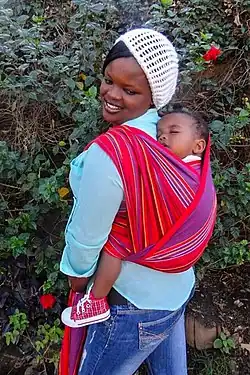 Niño llevado a cuestas en una envoltura kikoi Toto