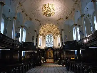 Iglesia de St. Clement Danes en Londres, con un relieve de las armas reales del Reino Unido, que representan el monarca británico como jefe de la Iglesia de Inglaterra.