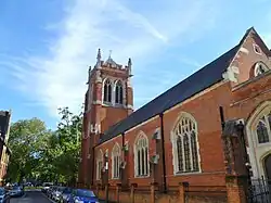 St Dionis (1884-1885), Parsons Green, Londres, torre completada en 1896, que muestra la nave lateral norte y la torre noreste, la iglesia tiene un estilo gótico perpendicular, menos típico de Christian[CP 5]​