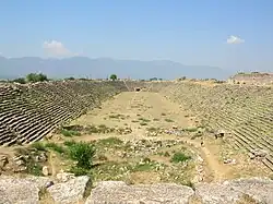 El estadio de Afrodisias, uno de los pocos vestigios que nos quedan de esa ciudad grecorromana, conocida en su tiempo por sus bellos edificios de mármol. El estadio es, de hecho, una mezcla entre un coliseo y una pista griega. La razón de ello se debe a que celebraban batallas sangrientas y al mismo tiempo juegos como lanzamiento de discos.