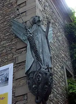 Escultura de San Miguel situada en el exterior de la iglesia.