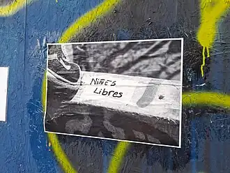 Pegatina de imagen con lema pro-niñez sobre una muralla azul