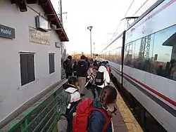Grupo de personas subiendo al tren en la estación de Ortigosa del Monte