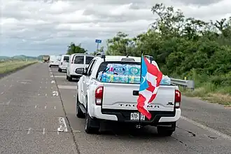Una camioneta Toyota Tacoma en la PR-52 sur con agua embotellada y la bandera de Puerto Rico después del huracán María (2017)