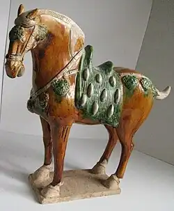 Caballo de guerra de la dinastía Tang (de los denominados celestiales o de Ferghana), representado en cerámica sancai.
