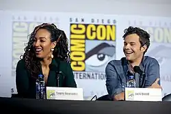 Tawny Newsome and Jack Quaid at a table on stage at Comic-Con