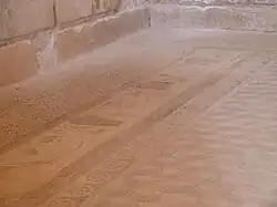 Detalle del mosaico geométrico de cubos con la tira perimetral de volutas de hiedra y máscaras de teatro.