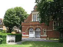 Detalle de la iglesia de St. Michael and All Angels. La silla de piedra a la izquierda es el monumento local de la Primera Guerra Mundial